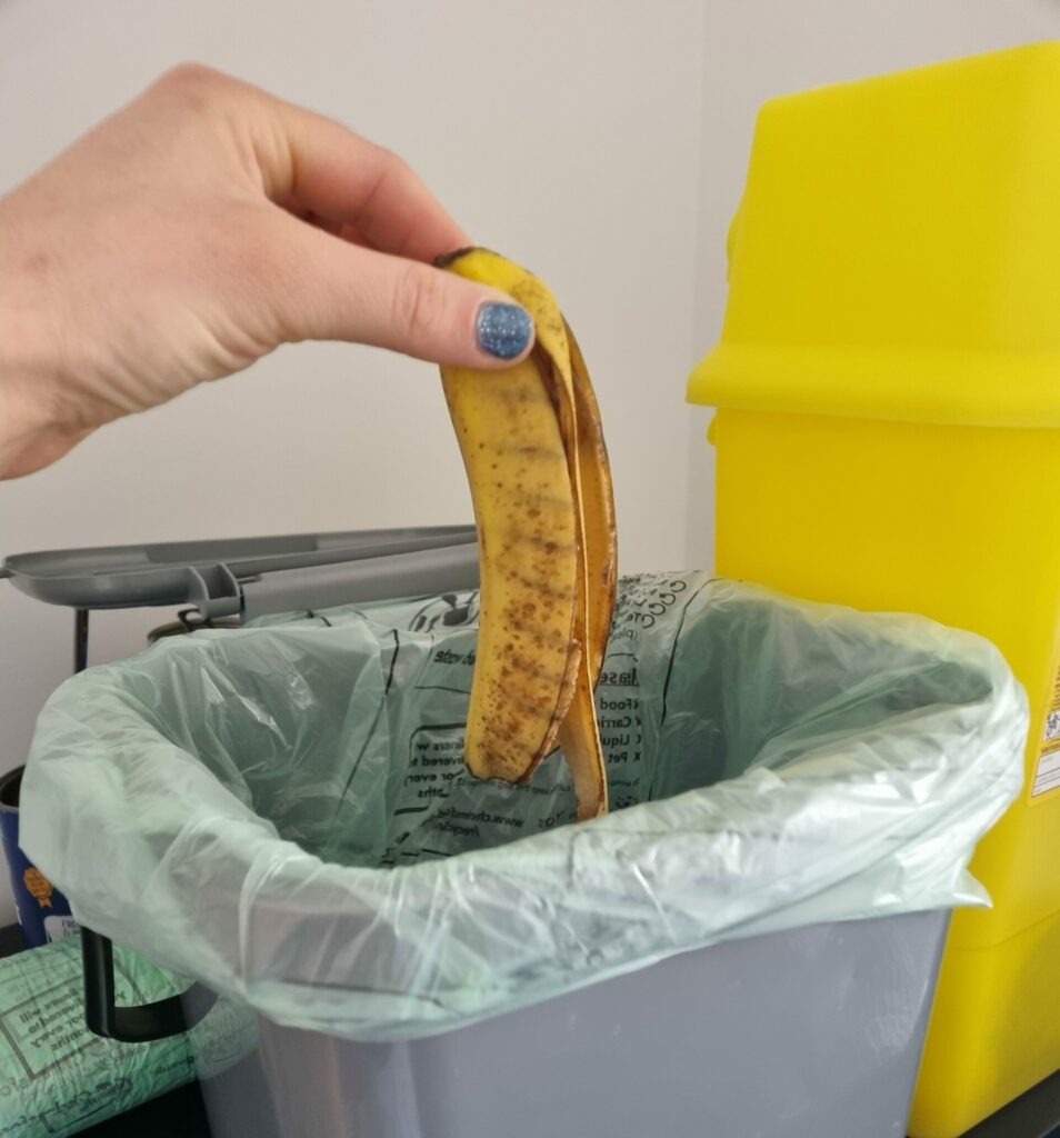Photo of banana skin being put in food waste bin