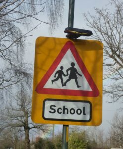 Triangle shaped sign, warning of school crossing nearby