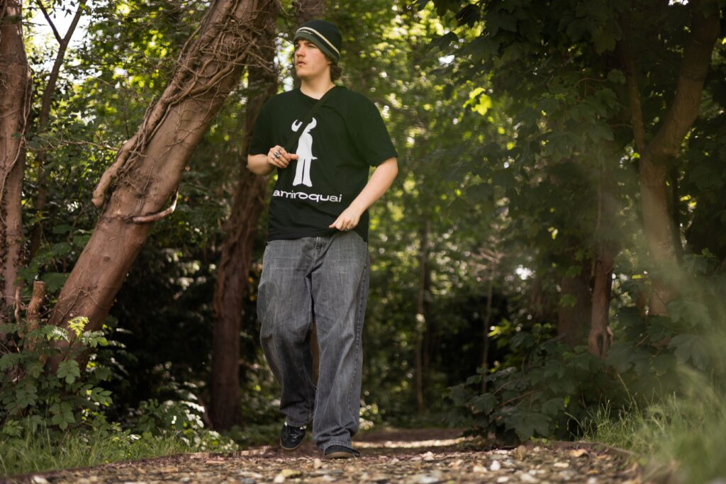 A teenage boy walking in the woods.
